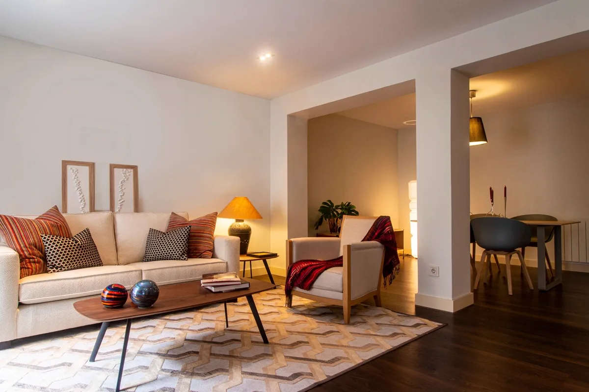Séjour d'appartement éclairé par une lampe, canapé et table basse